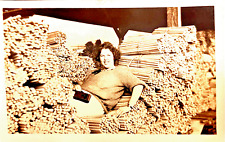 Authentic 1922 RPPC PRETTY Woman Resting in a HUGE PILE of DOWEL RODS - Very ODD picture