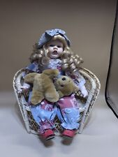 VERY PRETTY DOLL WHOSE BEAR HAS LOST ITS HEAD AND IS CRYING SITTING ON A CHAIR picture
