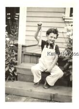 FOUND B&W PHOTO H_9702 LITTLE BOY SITTING ON STEP HOLDING A CARROT picture