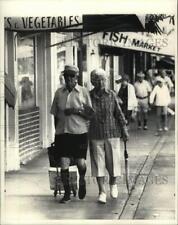 1985 Press Photo Two Elderly Shoppers Stroll Past Miami Beach's South Beach Shop picture