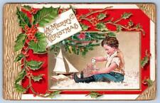 1910 MERRY CHRISTMAS CHILD PLAYS WITH ALPHABET BLOCKS EMBOSSED DESSIN POSTCARD picture