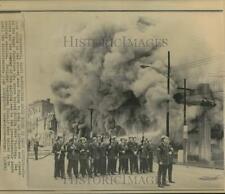 1968 Press Photo Policemen stand guard as Cincinnati store burns during rioting picture