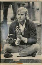 1967 Press Photo Anti-war demonstrator clutches wilted daisies, Oakland, CA picture