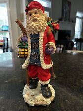 12” Resin Santa With Skis Holding A Lantern With A Bag Of Presents picture