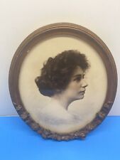 Antique wooden oval portrait frame with decorations and vintage woman picture picture
