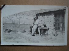 Sod house on prairie with two people and two turkeys. 1921.   writing on back  picture