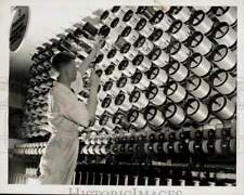 1939 Press Photo Worker adjusts spools of spun fiberglass filament at factory picture