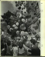 1985 Press Photo Mayor Henry Cisneros helps children in releasing balloons picture