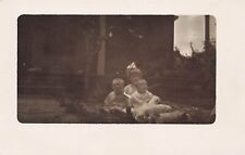 Vintage RPPC 1920s three small children sitting on grass divided back picture