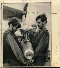 1971 Press Photo Bearded Armorers load bomb under jet aboard carrier Kitty Hawk picture
