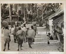 1945 Press Photo Natives Carrying Bags of Rice Through Village in Malaya picture