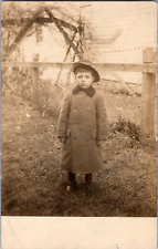 C. 1910 RPPC Cute Unhappy Young Boy Photo Posing Side Yard Fence Boots Wool Coat picture