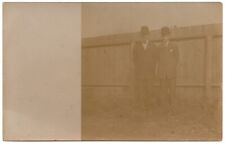 RPPC POSTCARD CIRCA 1920s TWO DAPPER MEN STANDING OUTSIDE BY FENCE UNMARKED picture